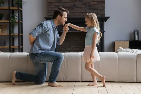 Vater kniet vor seiner Tochter nieder.